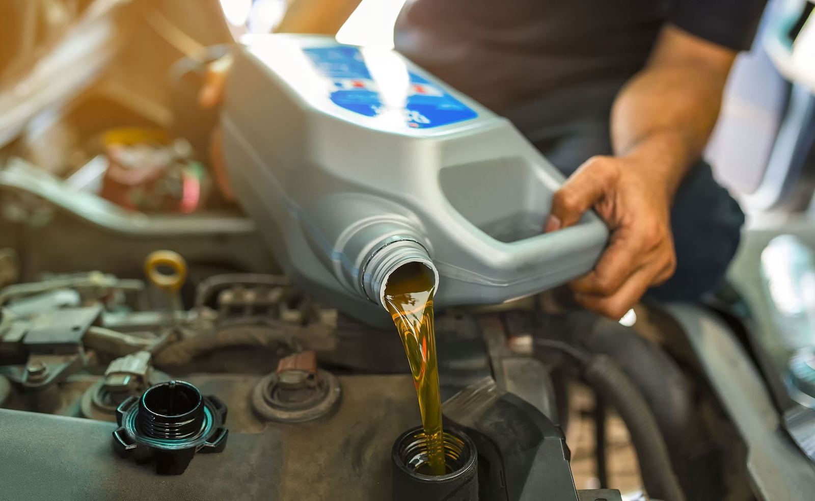 Fresh oil being poured into a car engine