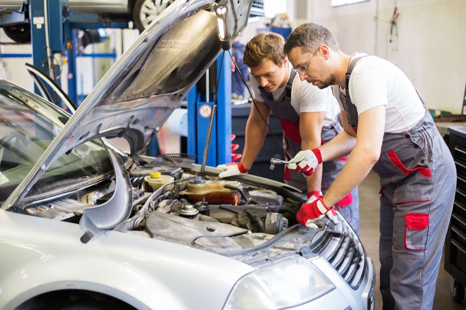 Mechanics at work under the hood at an auto shop